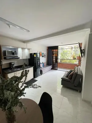 a large living room with a couch and a kitchen at Premium Location Comfort in Medellín