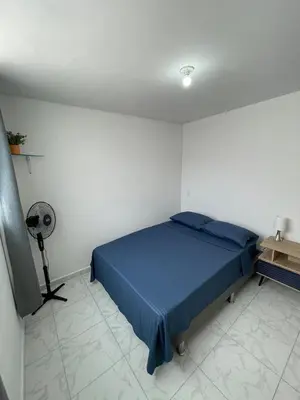 a bedroom with a blue bed and a fan at Premium Location Comfort in Medellín