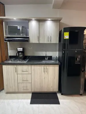 a kitchen with a black refrigerator and a sink at Premium Location Comfort in Medellín