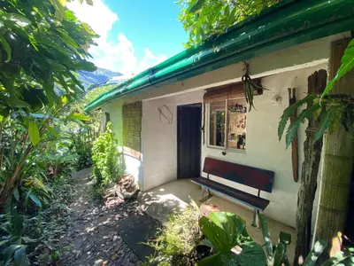 a bench sitting outside of a building with a window at Casa blanca, Refugio Natural Jacaranda in Cocorná