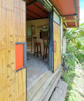 an open door of a wooden house with a table and chairs at Casa Azúl, Refugio Natural Jacaranda in Cocorná