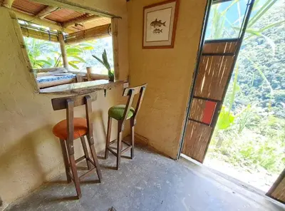a room with two stools in a room with a window at Casa Azúl, Refugio Natural Jacaranda in Cocorná