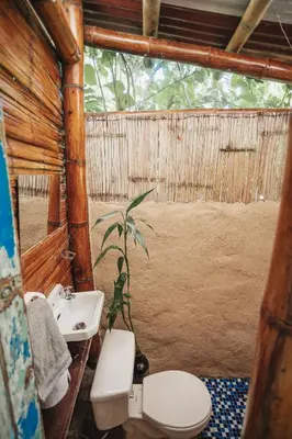 a bathroom with a toilet and a sink and a plant at Casa Azúl, Refugio Natural Jacaranda in Cocorná