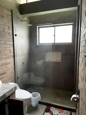 a bathroom with a toilet and a sink and a window at Casa de Campo in Manizales