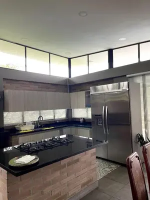 a kitchen with a stainless steel refrigerator and a stove at Casa de Campo in Manizales