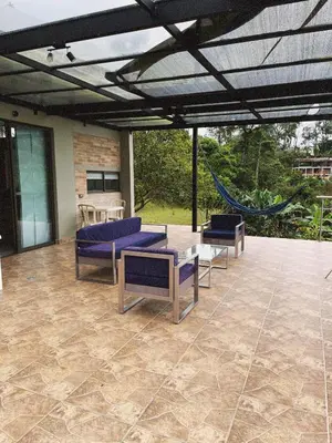 a patio with couches and a hammock on it at Casa de Campo in Manizales