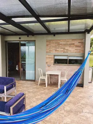 a hammock on a patio with a table and chairs at Casa de Campo in Manizales