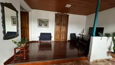 a living room with wooden floors and a mirror at El Balcón de Emma in Jardin