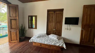 a bedroom with a bed and a flat screen tv at El Balcón de Emma in Jardin