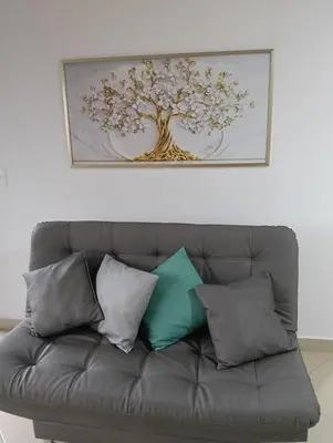 a picture of a tree above a couch with pillows at Hospedaje samfer in Envigado
