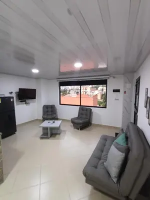 a living room with two couches and a tv at Hospedaje samfer in Envigado