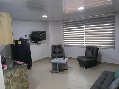 a room with two chairs and a table and a tv at Hospedaje samfer in Envigado