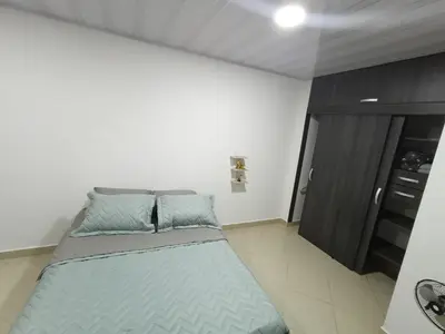 a bedroom with a large bed with blue pillows at Hospedaje samfer in Envigado