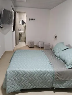 a bedroom with a large bed and a bathroom at Hospedaje samfer in Envigado