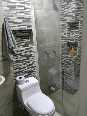 a bathroom with a toilet and a glass shower at Hospedaje samfer in Envigado