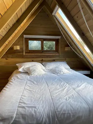 a large bed in a attic with a window at Hermoso chalet en marinilla in Marinilla