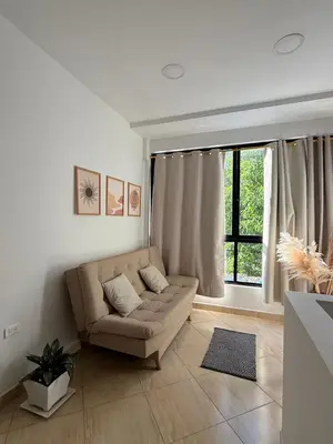 a living room with a couch and a window at Alojamiento en Doradal - Apartaestudio central in Doradal