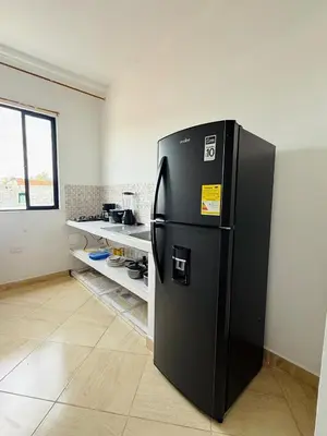 a kitchen with a black refrigerator in a room at Alojamiento en Doradal - Apartaestudio central in Doradal