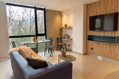a living room with a couch and a table at Stadio Aparta Rosa Negra Suite in Medellín
