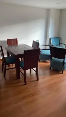 a dining room with a wooden table and chairs at Pie de Cerro Condominium in Medellín