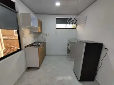 a kitchen with a stove and a sink in a room at Apartahotel-sevilla in Medellín