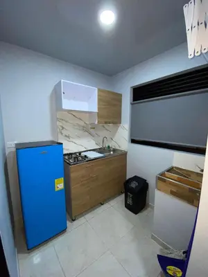 a kitchen with a blue refrigerator and a sink at Apartahotel-sevilla in Medellín