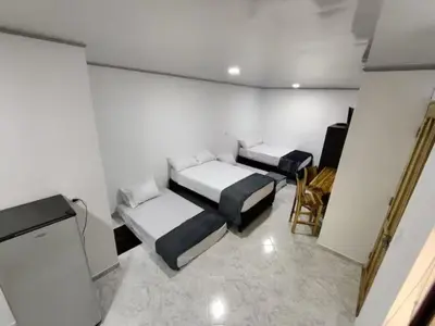 a room with two beds and a tv in it at Apartahotel-sevilla in Medellín
