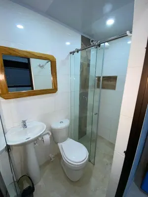 a bathroom with a toilet and a glass shower at Apartahotel-sevilla in Medellín
