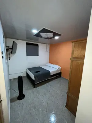 a bedroom with a bed and a tv in it at Apartahotel-sevilla in Medellín