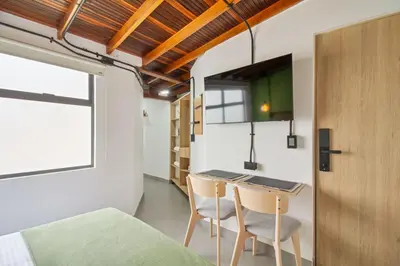 a room with a bed and a table and chairs at Studio30 A, Belen, Los Molinos in Medellín