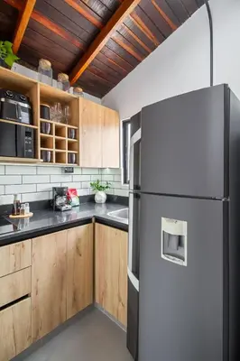 a kitchen with a refrigerator and wooden cabinets at Studio30 A, Belen, Los Molinos in Medellín
