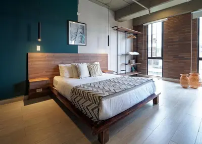 a bedroom with a large bed with a wooden headboard at Stylish Loft in the Heart of Laureles in Medellín