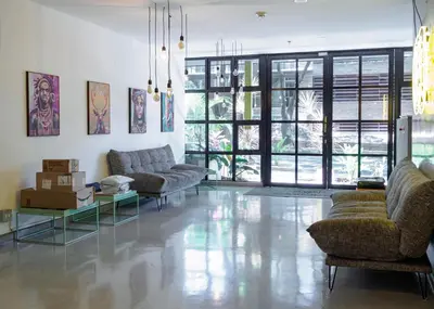 a living room with couches and tables and windows at Stylish Loft in the Heart of Laureles in Medellín