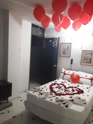 a bedroom with a bed with red balloons on it at Hotel La Rosa in Mariquita