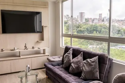 a living room with a couch and a flat screen tv at CENTRO historico y CC FUNDADORES in Manizales