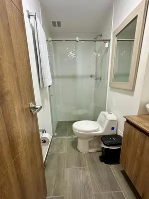 a bathroom with a toilet and a glass shower at CENTRO historico y CC FUNDADORES in Manizales