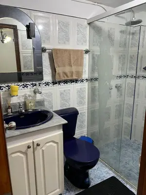 a bathroom with a blue toilet and a shower at Cómoda y Amplia Casa, Ideal Para Grupos, Muy Cerca Del Estadio, Barrio La América in Medellín