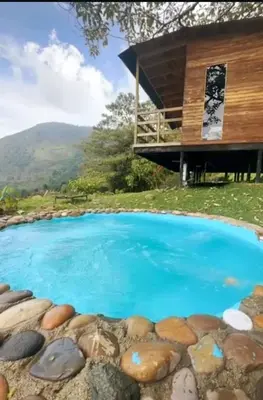 a large swimming pool with a house in the background at Refugio Tororoi in Copacabana
