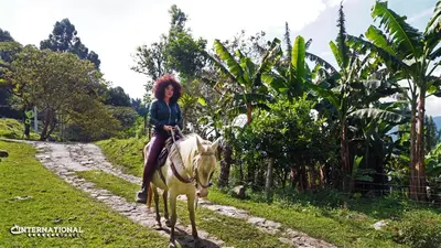 a woman riding a horse down a dirt road at Refugio Tororoi in Copacabana