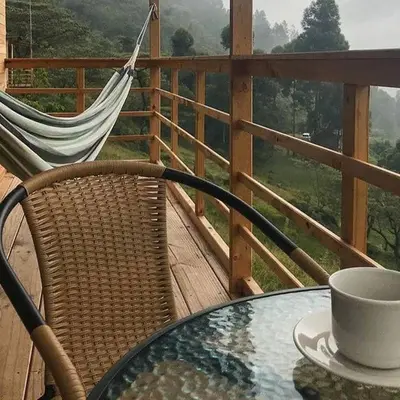 a table with a coffee cup and a hammock on a balcony at Refugio Tororoi in Copacabana