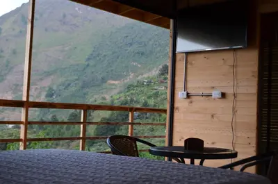 a room with a table and chairs and a view of a mountain at Refugio Tororoi in Copacabana