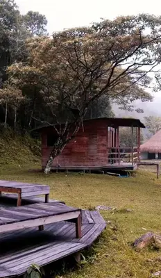 two picnic tables in front of a small building at Refugio Tororoi in Copacabana