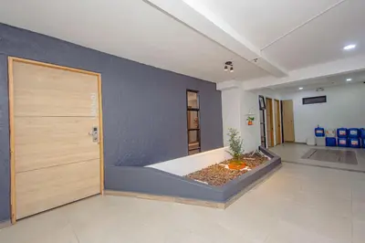 a large room with a door and a plant on the floor at Novus Laureles in Medellín