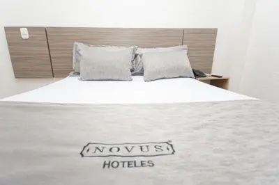 a bedroom with a large bed with a n arousalhotles sign on it at Novus Laureles in Medellín