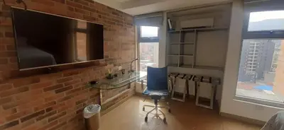 a living room with a tv and a blue chair at Luxury Laureles-LA 70-Medellin Stunner in Medellín