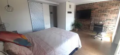 a bedroom with a bed and a brick wall at Modern, Stylish, Awesome Locacion, Gorgeous Views in Medellín