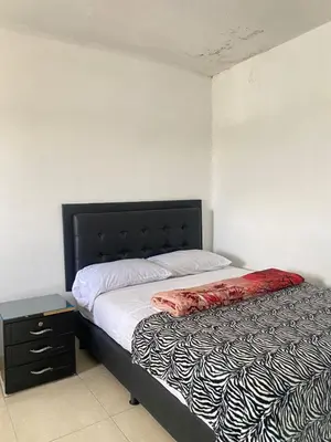 a bedroom with a bed with a black and white comforter at Hotel La Aldea in Guatapé