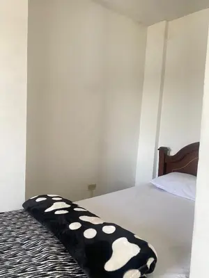 a black and white blanket sitting on a bed at Hotel La Aldea in Guatapé