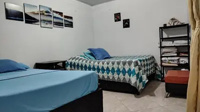 a bedroom with two beds and a shelf with clothes at DESTINY Apto Central in San Rafael