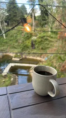 a cup of coffee sitting on a table in front of a window at Finca 5 Continentes - Cerca MatroCable ARVI in Guarne